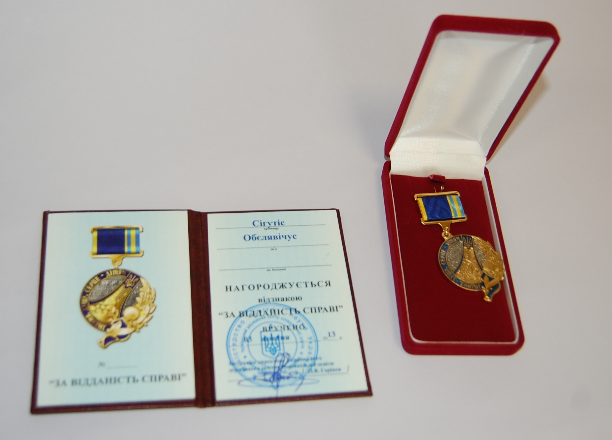 Medalis, įteiktas Sigučiui Obelevičiui, ir jo dokumentas.
