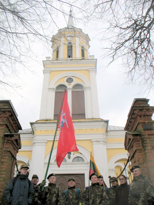 Prie baltojo Šv. Jono Krikštytojo bažnyčios bokšto.