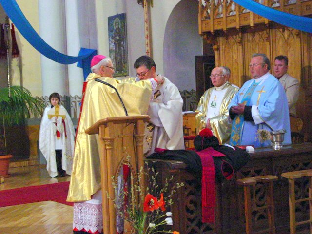 Vyskupas J.Kauneckas įteikia kanauninko insignijas S.Krumpliauskui.