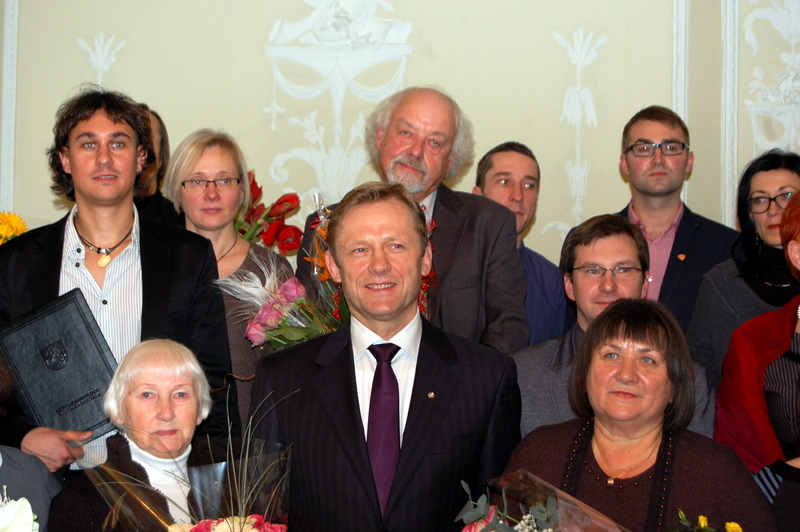 Rašytojas R. Vanagas kukliai slepiasi už premiją įteikusio Kultūros ministro Šarūno Biručio... Audronės Pajarskienės nuotrauka.